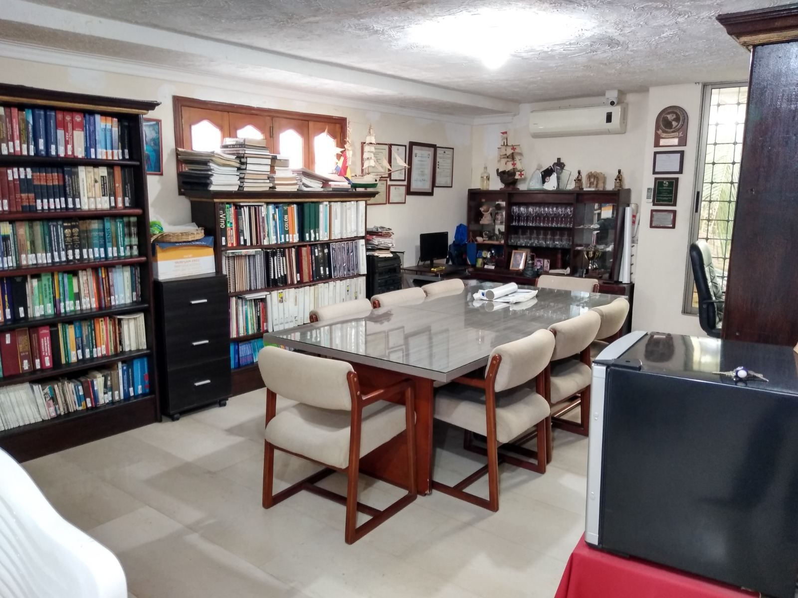 Biblioteca de Casa Feliza, con estanterías llenas de libros y una mesa de reuniones