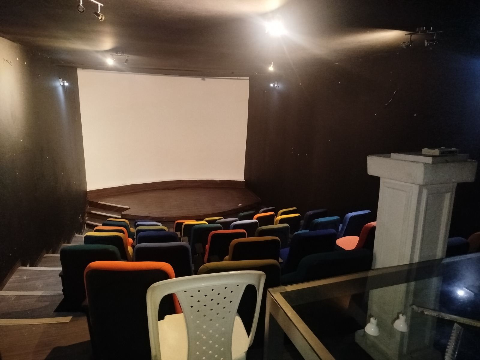 Sala de cine comunitaria de Casa Feliza, con butacas de colores y pantalla de proyección