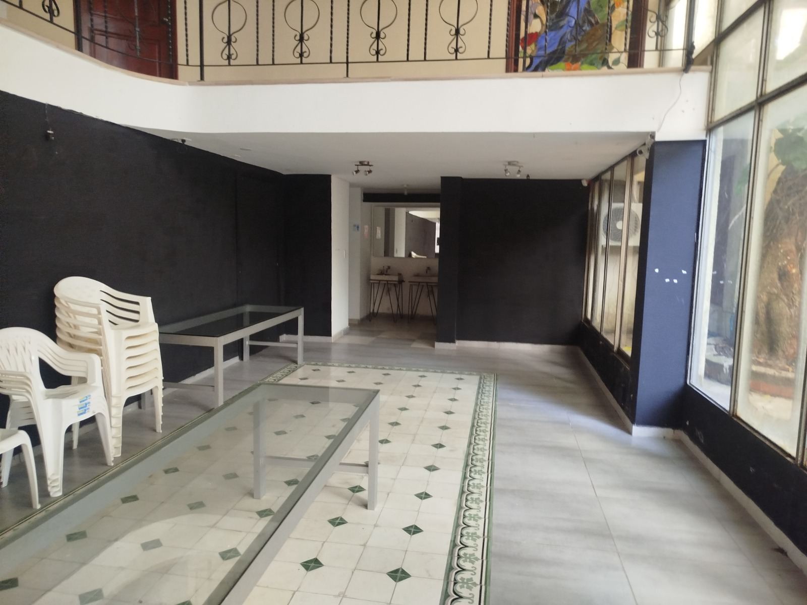 Mezzanine de Casa Feliza con baranda de hierro forjado y vitral
